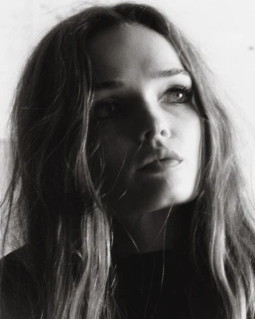 Close-up monochrome portrait of a woman with long hair looking upward in natural light by photographer Hanna Tveite.