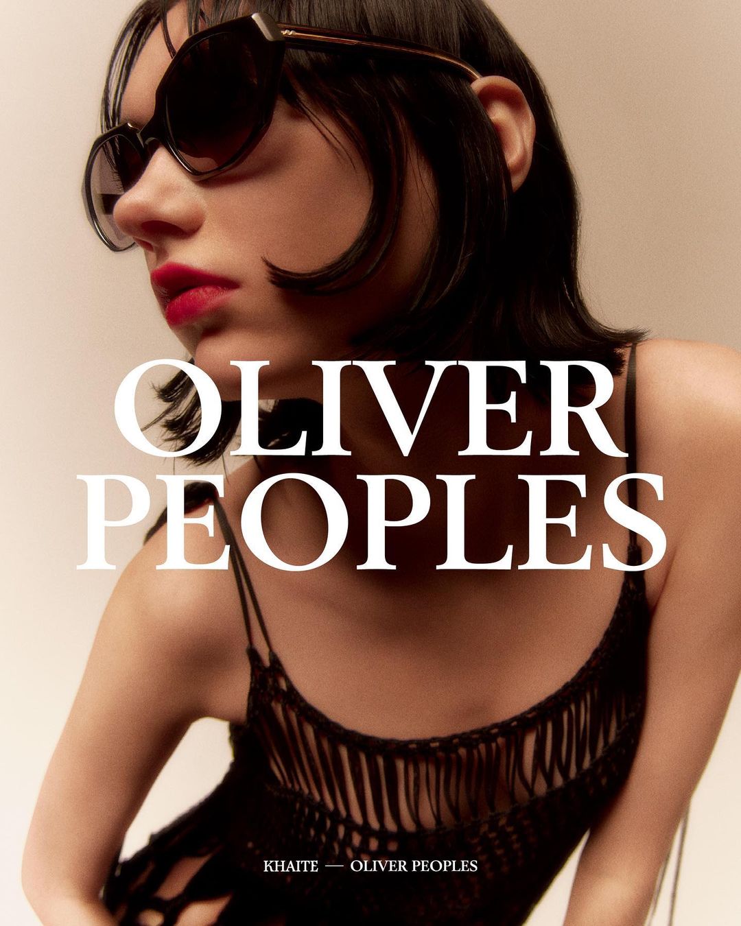 Fashion shot of woman wearing sunglasses and a black fringe top against a neutral backdrop with OLIVER PEOPLES text.