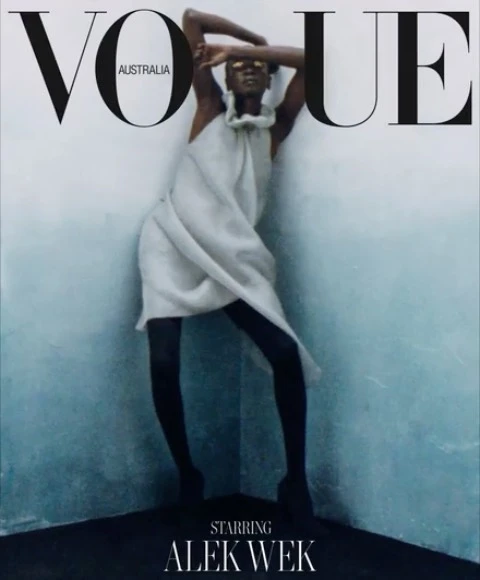 Vogue Australia magazine cover featuring Alek Wek in a light dress and sunglasses posing in front of a textured wall in a corner.