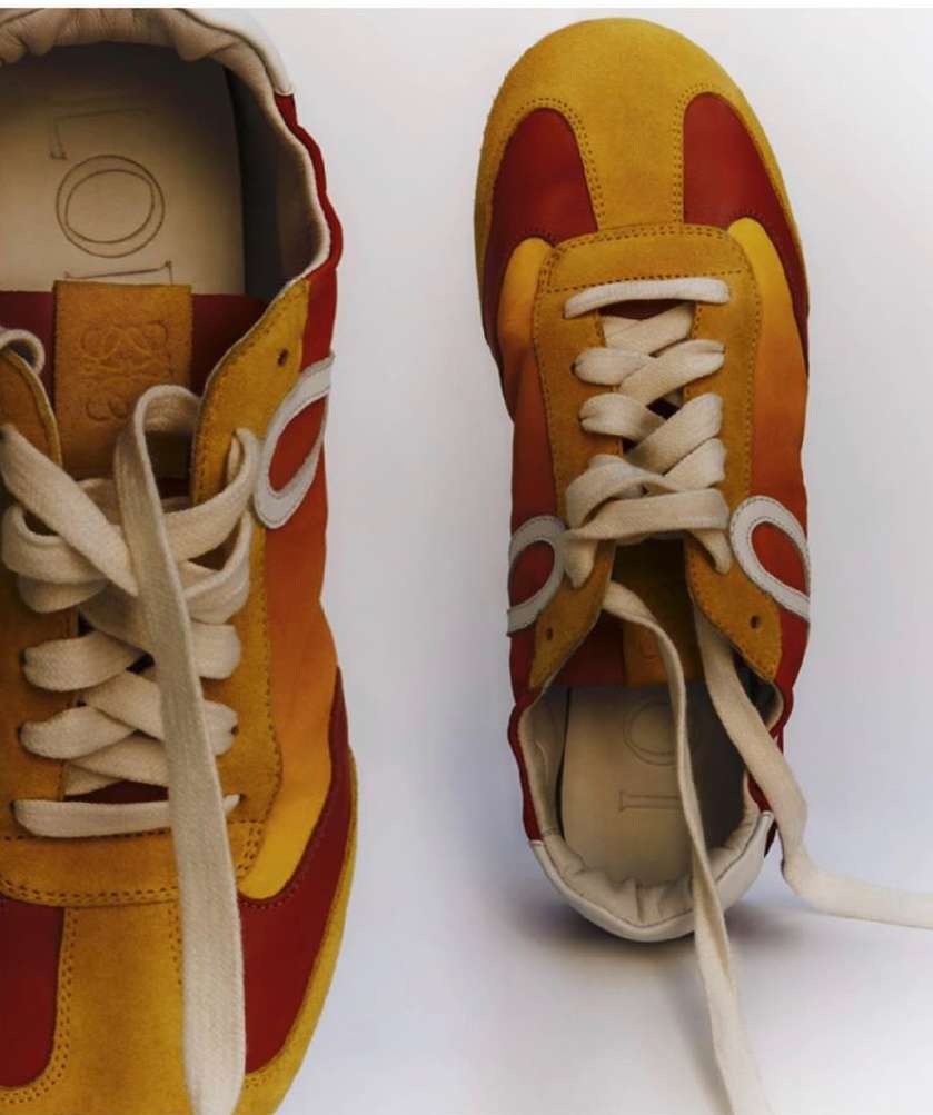 Two retro-style sneakers are displayed against a white background, featuring yellow and red suede with white laces and trim.