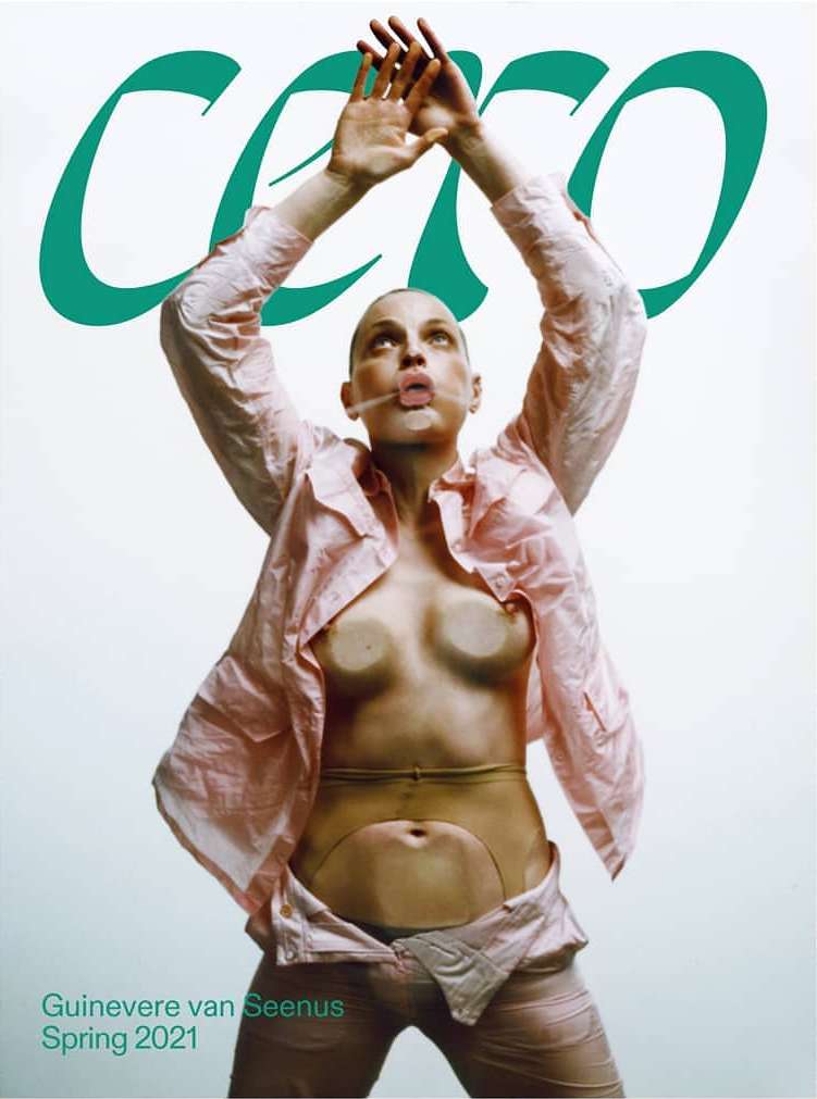 Magazine cover featuring a woman in a pink shirt with hands raised, against a light background with green lettering and brand name.