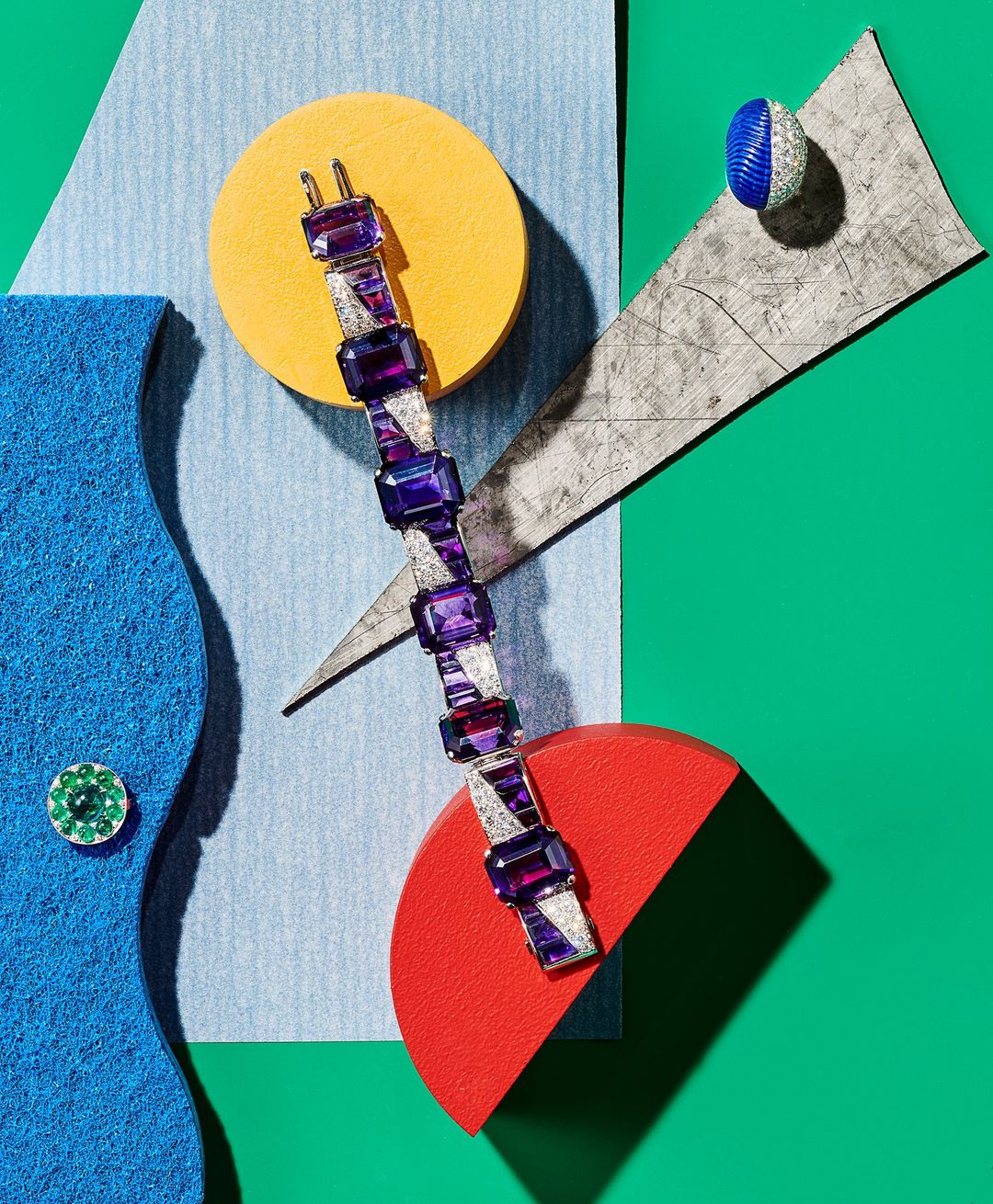 Amethyst and diamond bracelet on a geometric background of yellow, red, blue, green, and gray shapes in a brightly lit studio shot.
