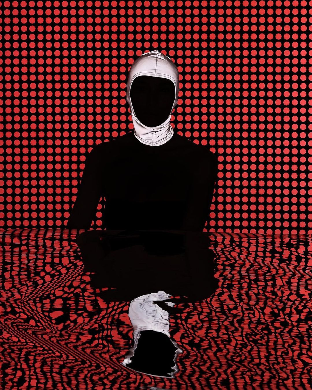 Abstract art of a person wearing a reflective balaclava, posed in a lotus position in front of a red and black dotted background.