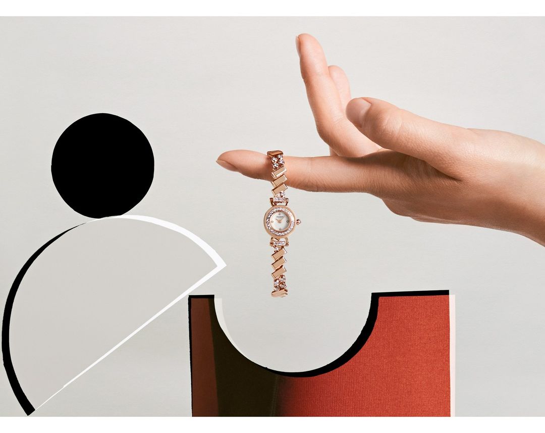 Elegant wrist watch on fingertip with minimalist geometric backdrop. Sophisticated fashion accessory in a modern, stylized product display.