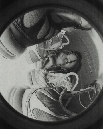 Monochrome portrait of an adult female framed by athletic shoes within a circular border, creating a unique and surreal composition.