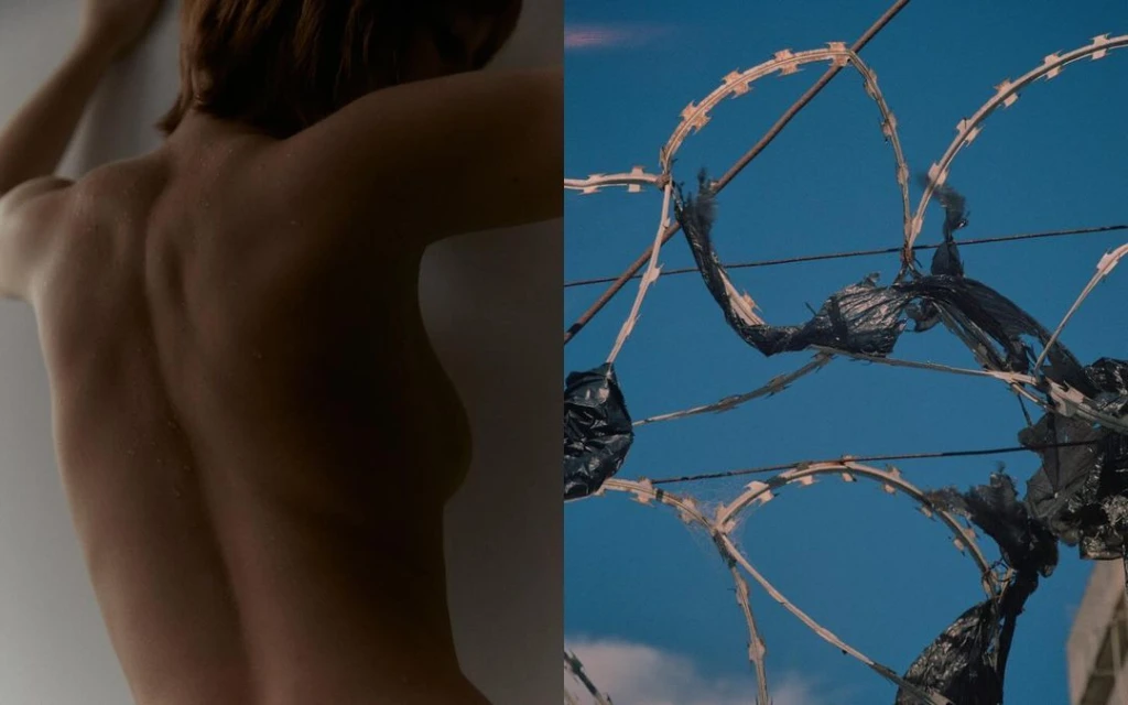 Artistic composition with nude woman's back juxtaposed against a chain-link fence and blue sky with razor wire in outdoor setting.