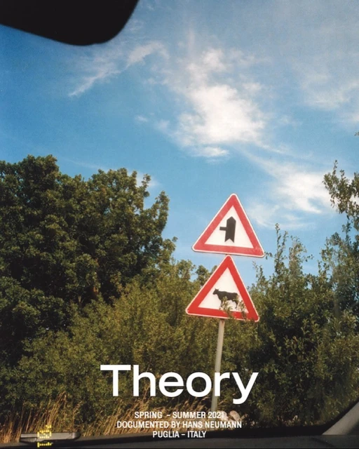 Traffic sign with cow symbol in a rural area under a blue sky, seen from inside a car, with trees and greenery in the background.