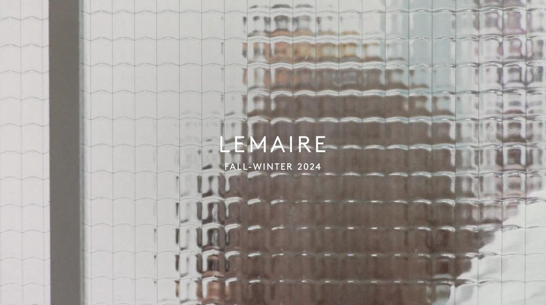 Text overlay on textured glass, featuring brand name and season. Image provides a glimpse through an obscured window.