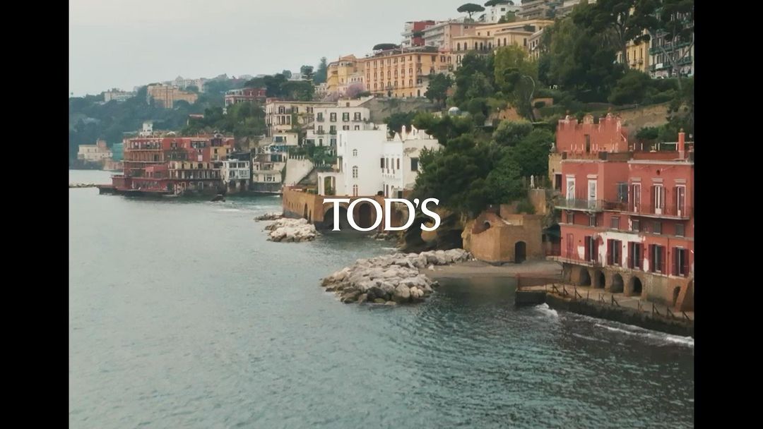 Coastal view of multicolored buildings on a hillside overlooking the sea, on an overcast day with soft, diffused lighting.