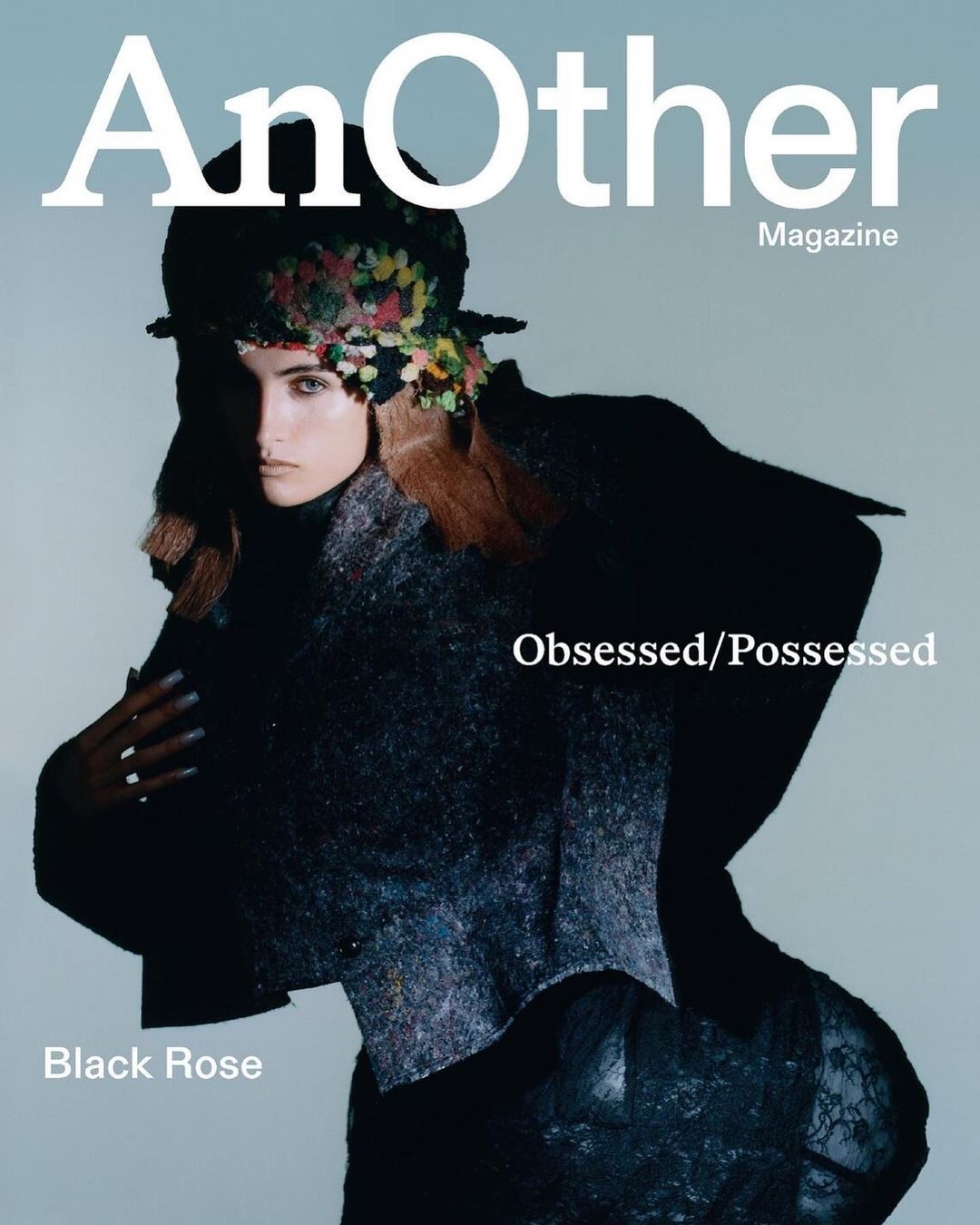 Magazine cover featuring a woman wearing an embellished hat and dark textured clothing, with 'AnOther Magazine' in white text.