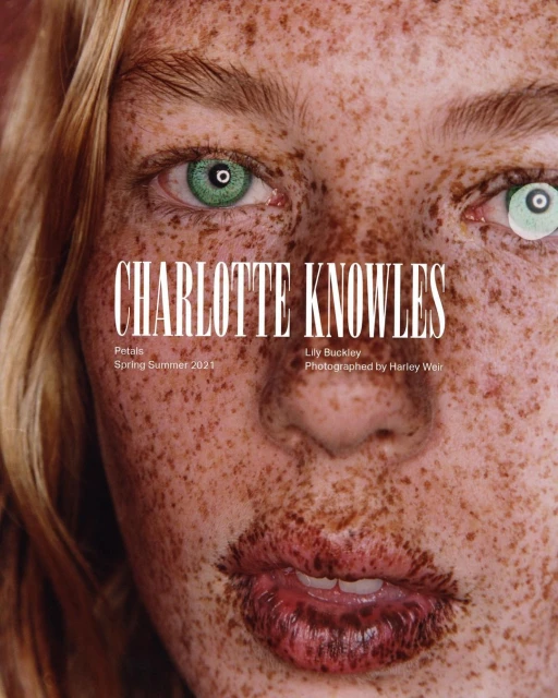 Close-up portrait of a freckled woman with heterochromia eyes, fair hair, and full lips, featuring a fashion magazine cover design with bold typography.
