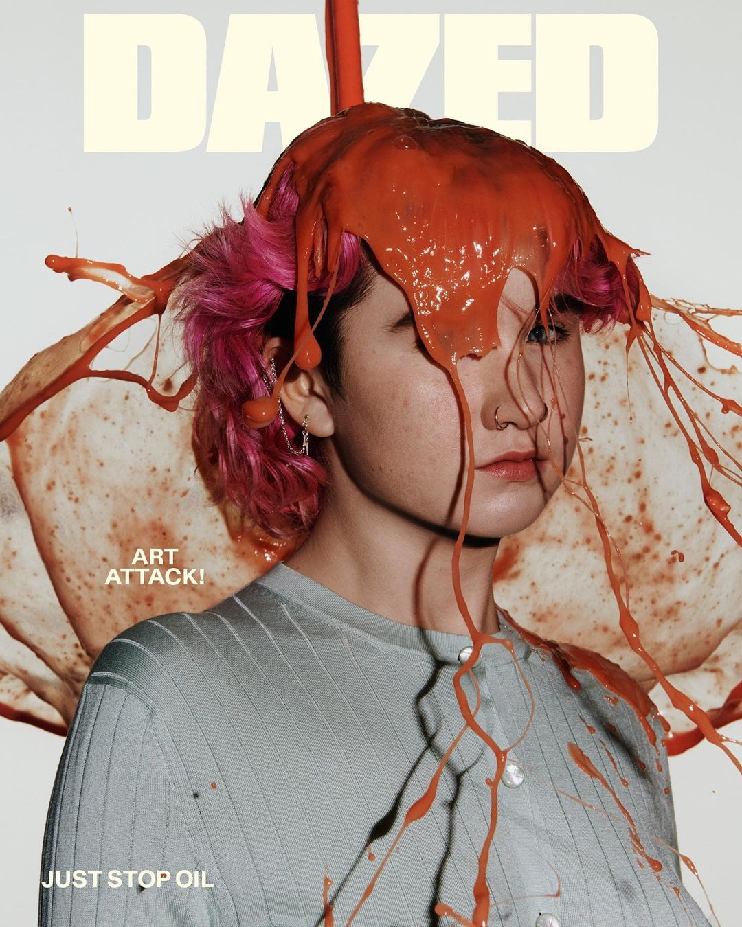 Dazed Magazine cover featuring person with bright pink hair and orange paint covering their head and shoulders on a white background.