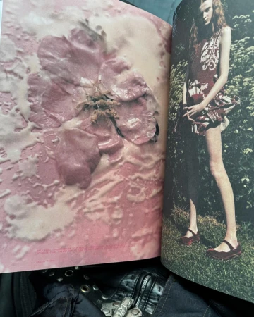 Magazine spread features a fashion model in a patterned dress in an outdoor setting, next to a close-up photo of a pink flower.