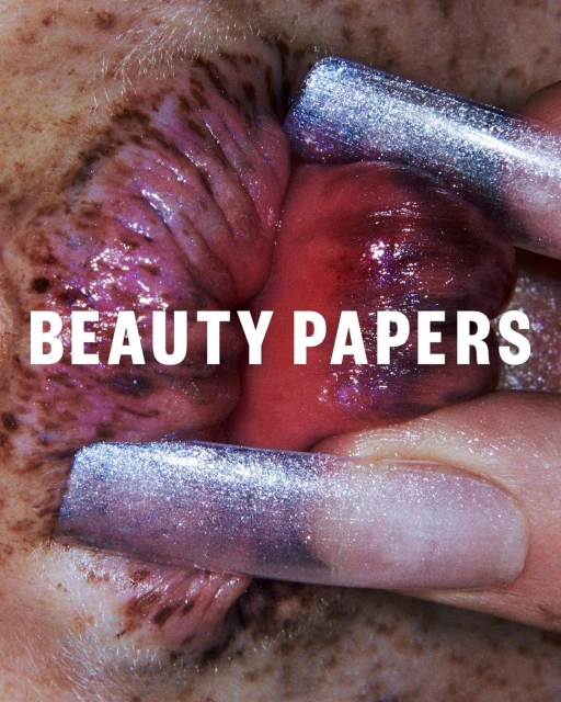 Close-up beauty shot of glittery fingernails pushing back skin to show the inner mouth and gums with the text BEAUTY PAPERS.