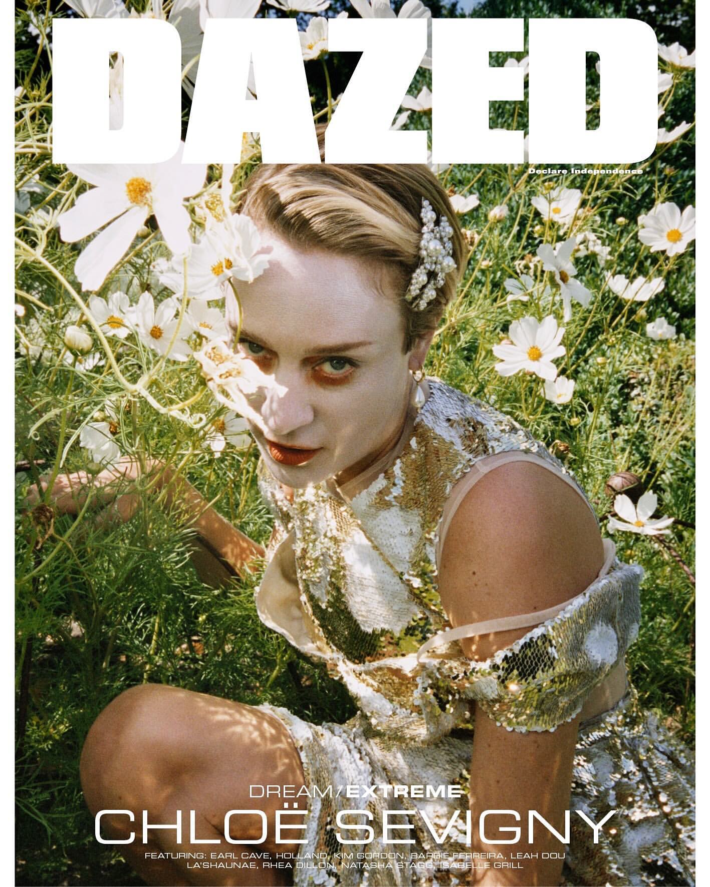Dazed magazine cover featuring Chloe Sevigny in a gold sequin dress, seated among white flowers and green plants, creating a natural and glamorous aesthetic.