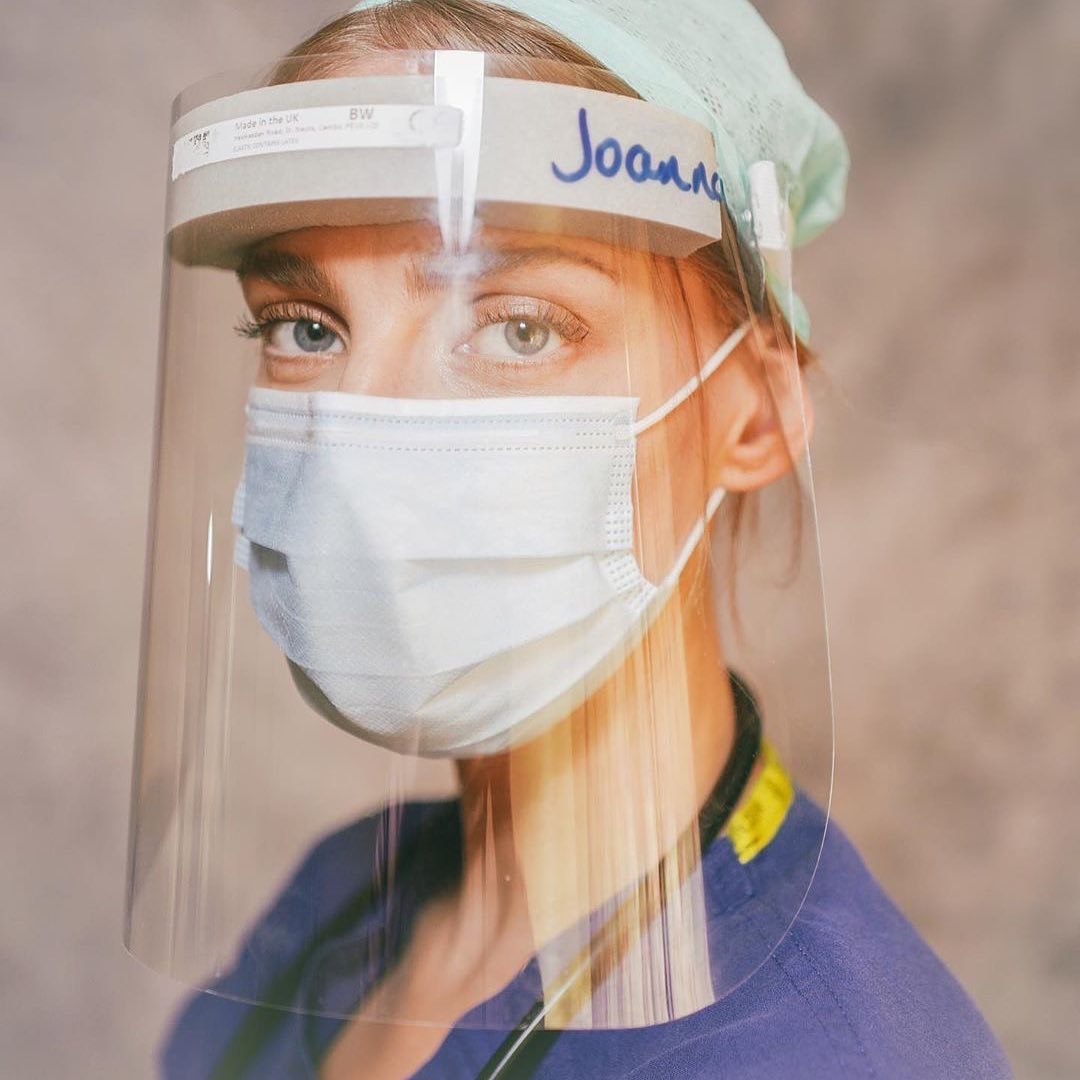 Medical professional in scrubs and face shield: protection against infection in a healthcare setting for safety and prevention.