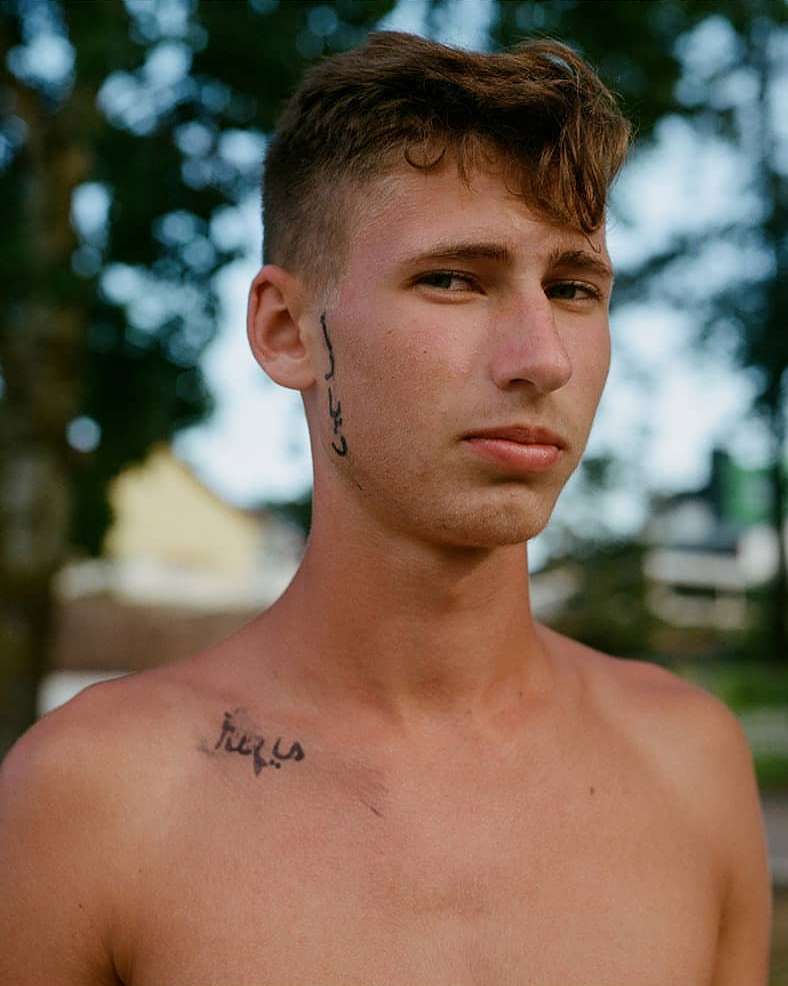 Portrait of a young man with facial and chest tattoos outdoors in London captured by Hazel Gaskin