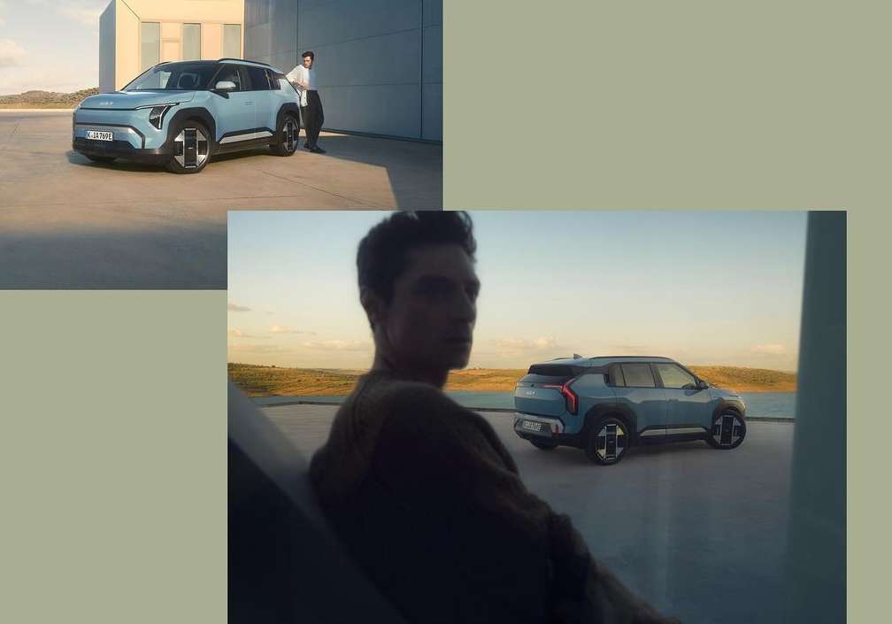 Light blue SUV parked next to an adult male in a grey shirt; a modern automotive scene with neutral colours and a rural backdrop.