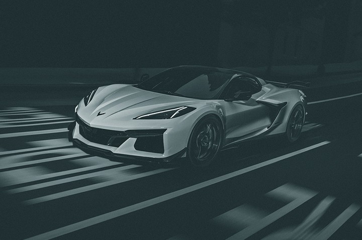 Sleek white sports car on a dimly lit road with prominent white stripes, showcasing a blend of modern design and high performance.