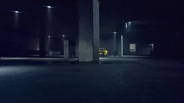 A dimly lit, cavernous parking garage featuring a single yellow car parked under the overhead lights, set against a dark, industrial backdrop.