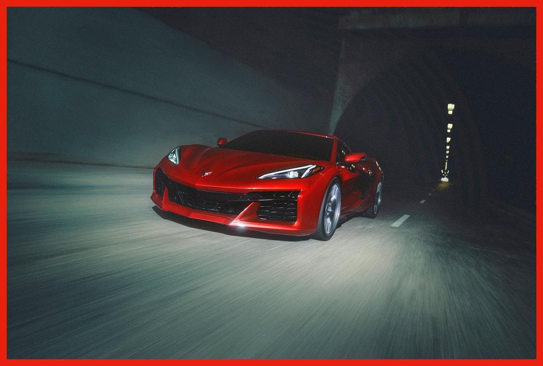 A vibrant red sports car speeds through a dark tunnel with motion blur, showcasing automotive performance and tunnel environment.