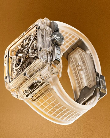 Luxury wristwatch with transparent case and rubber strap on a neutral background in a studio setting, showcasing intricate design and materials.