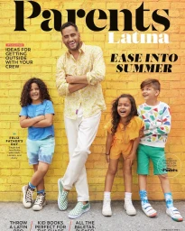 Man and four children smiling outdoors in front of a yellow brick wall with magazine typography overlay.