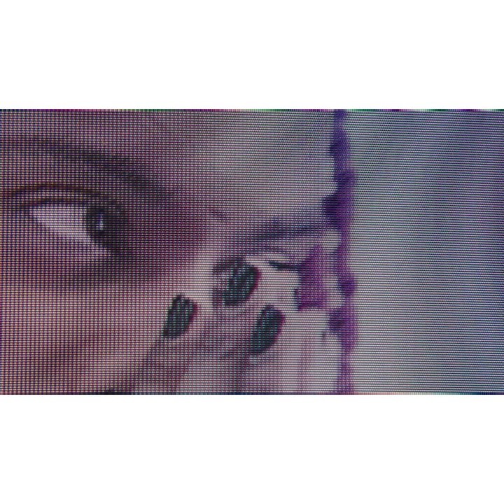 Close-up of a person's face partially visible with braided hair. The image shows the eye, parts of the cheek, and fingernails with dark polish.