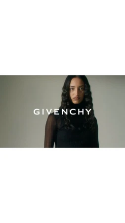 Model in black turtleneck standing against a neutral studio background with bold Givenchy text overlaid across the center.
