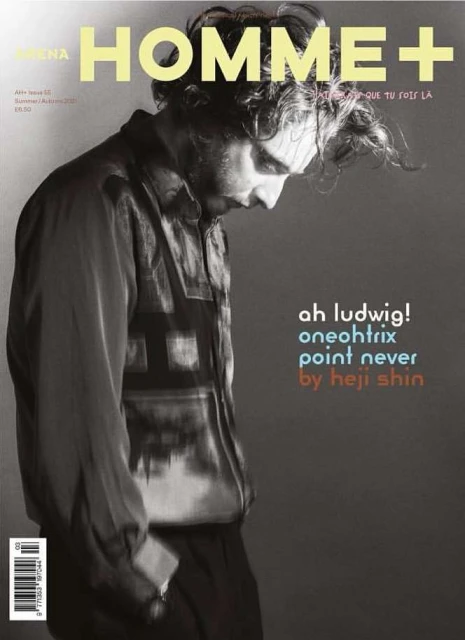 Arena Homme+ magazine cover featuring a contemplative adult male with tousled hair and a patterned shirt against a gray backdrop.