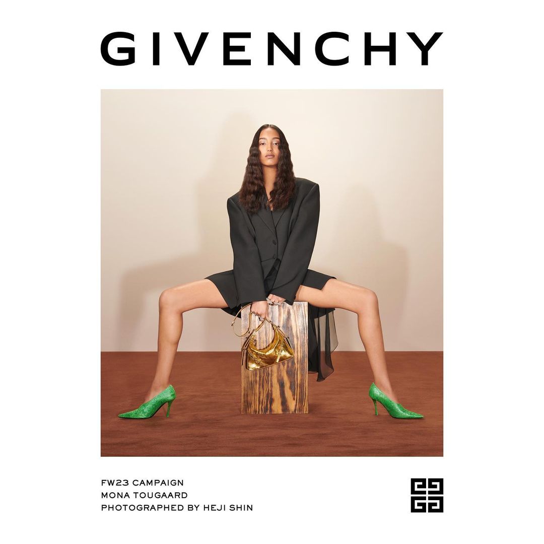 A fashion campaign image features a slender adult female in a black blazer dress, shimmering green heels, and a gold purse, set against a neutral backdrop.