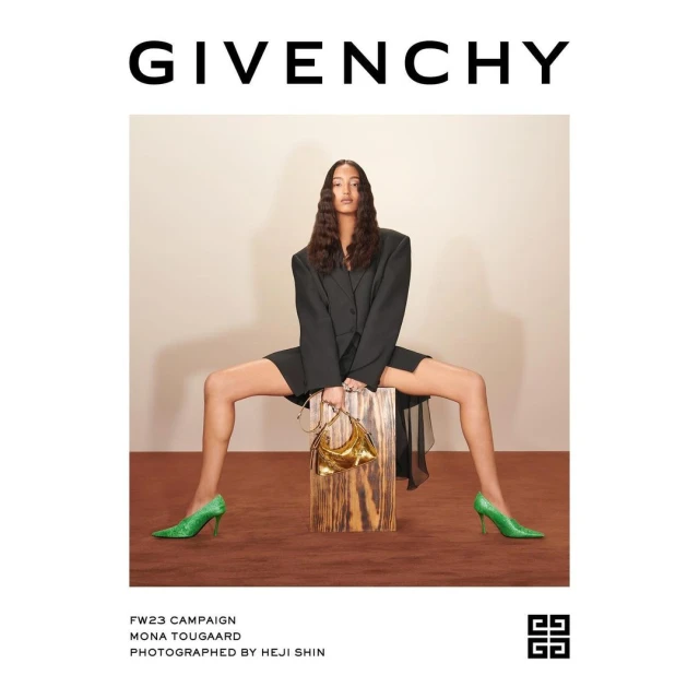 A fashion campaign image features a slender adult female in a black blazer dress, shimmering green heels, and a gold purse, set against a neutral backdrop.