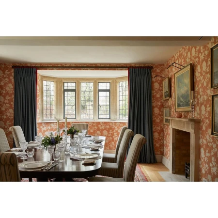 Formal dining room featuring a dark wood table set with plates and glassware, surrounded by upholstered chairs and floral wallpaper.