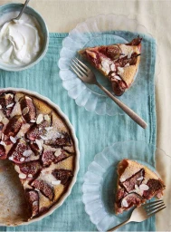 Overhead food photography of fig tart slices on glass plates with a bowl of cream and a turquoise linen cloth by Helen Cathcart
