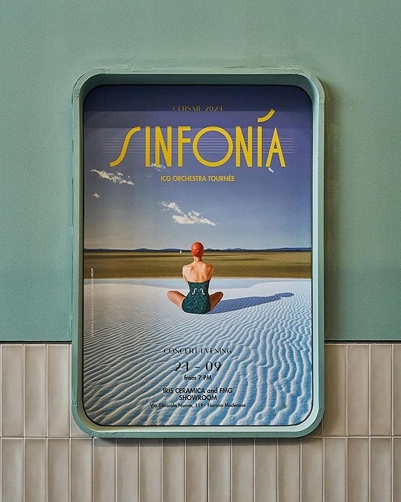 Poster art featuring a woman in a swimsuit sitting in sand dunes against a beach scene, promoting a concert in Iris Ceramica showroom.