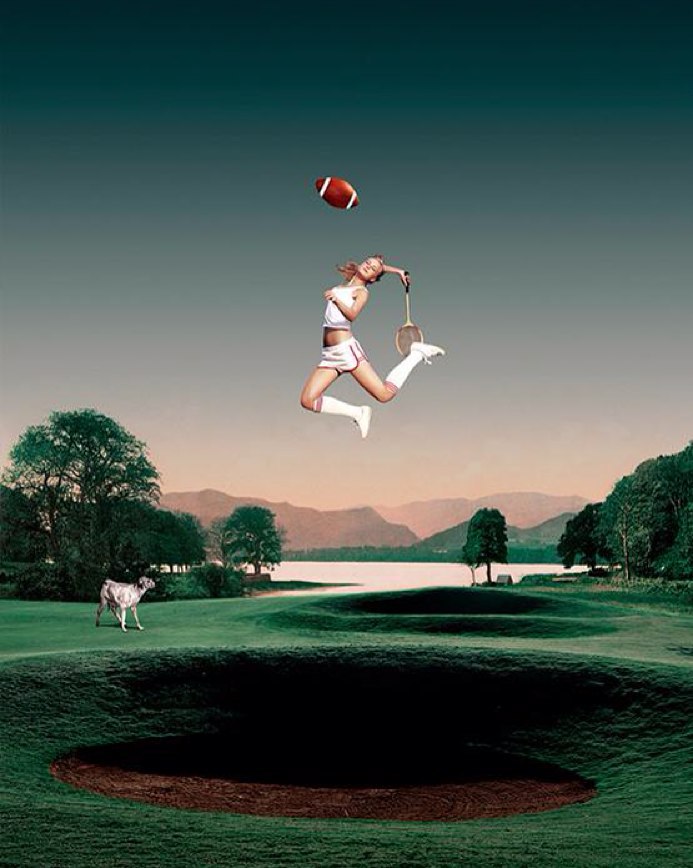 Female athlete in mid-air holding a badminton racket, with a football and a golf course in the background on a summer day.