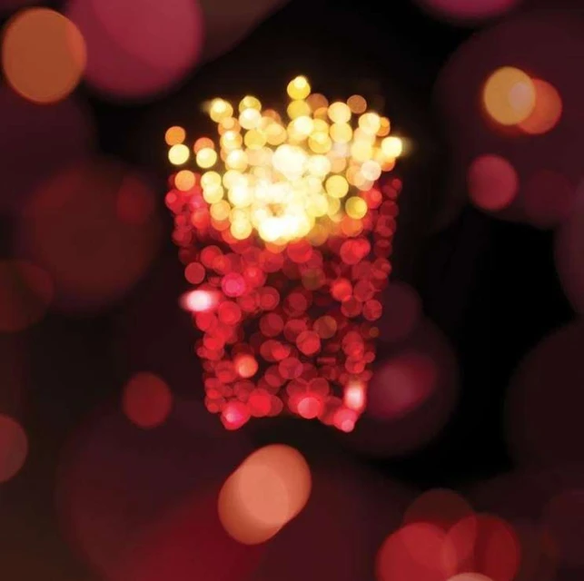 Stylized illustration of french fries in a red container, made with a bokeh effect. Warm colors and blurry background.
