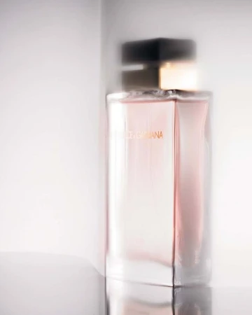 Close up perfume bottle in soft light against white background captured by Helmut Stelzenberger in Paris