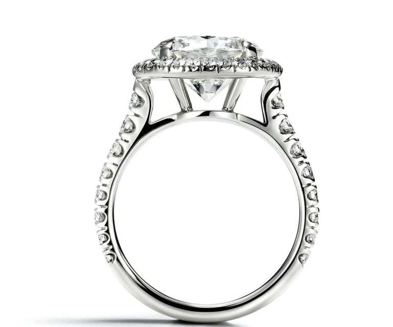 Close-up of a sparkling diamond ring with a pave setting on a white background, showcasing its intricate design and clarity.