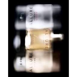 Vertical multiple exposure photograph of three stacked fragrance bottles against a dark background by Helmut Stelzenberger