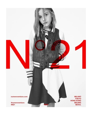 A young female child model wearing a varsity jacket and dark skirt against a white studio background with large red typography overlay.