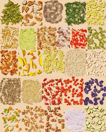 Overhead shot showcases various chopped and prepared foods including vegetables, fruits, nuts, and grains in individual piles.