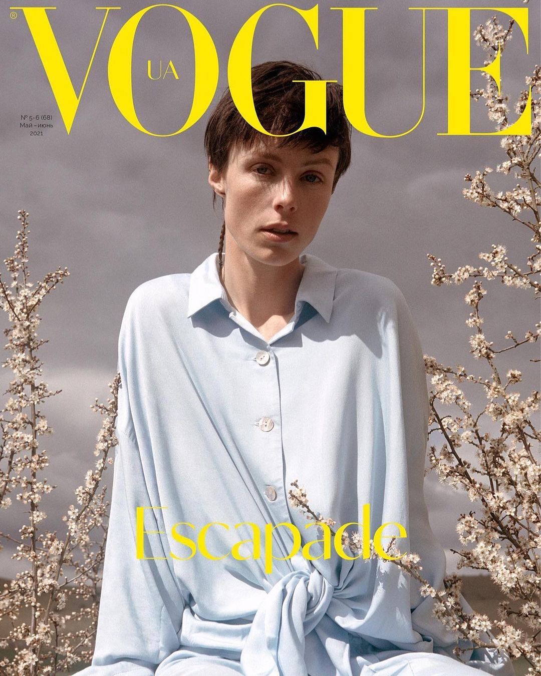 Vogue UA cover featuring a stylish adult female in a light blue button-down shirt, captured with natural light and blooming branches.