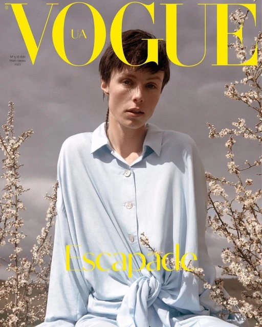 Vogue UA cover featuring a stylish adult female in a light blue button-down shirt, captured with natural light and blooming branches.