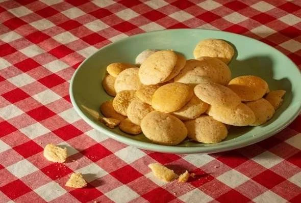 A plate of cookies on a red and white checkered tablecloth, food photography of a snack or dessert with a homemade vibe.