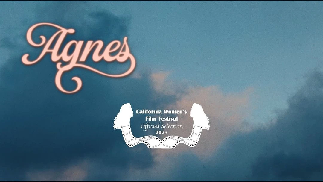 Film festival promotional image featuring the title 'Agnes' in stylized pink font against a sky background with cloud formations.