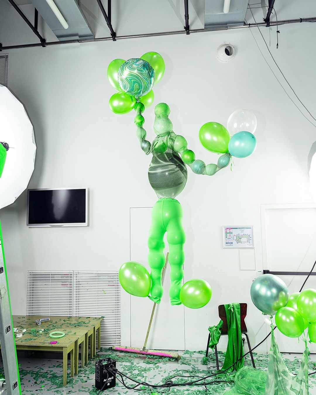 Studio shot of a balloon sculpture in an indoor setting featuring a green and white color scheme, creating a playful atmosphere.