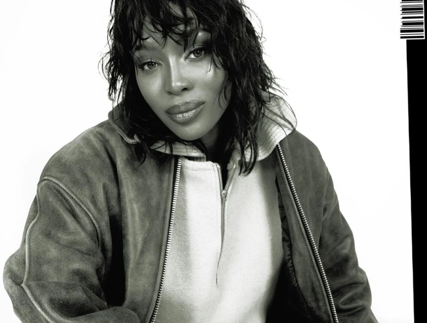 Headshot of an adult female with medium length dark hair, wearing a jacket and posing against a white background, with a partial barcode.