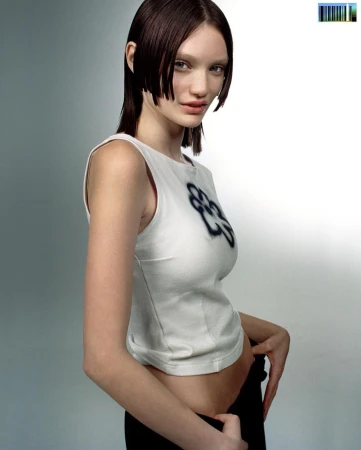 Model with dark chin length blunt haircut wearing a white sleeveless top with a dark floral graphic