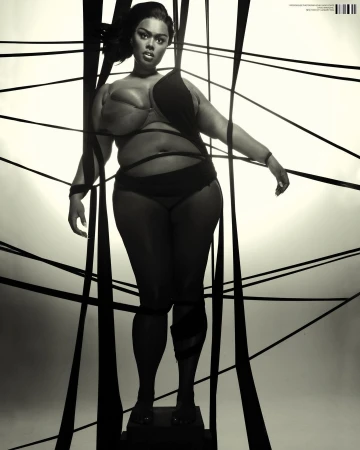 Model in black swimwear posed among crisscrossing black ribbons against a bright background by Hugo Comte
